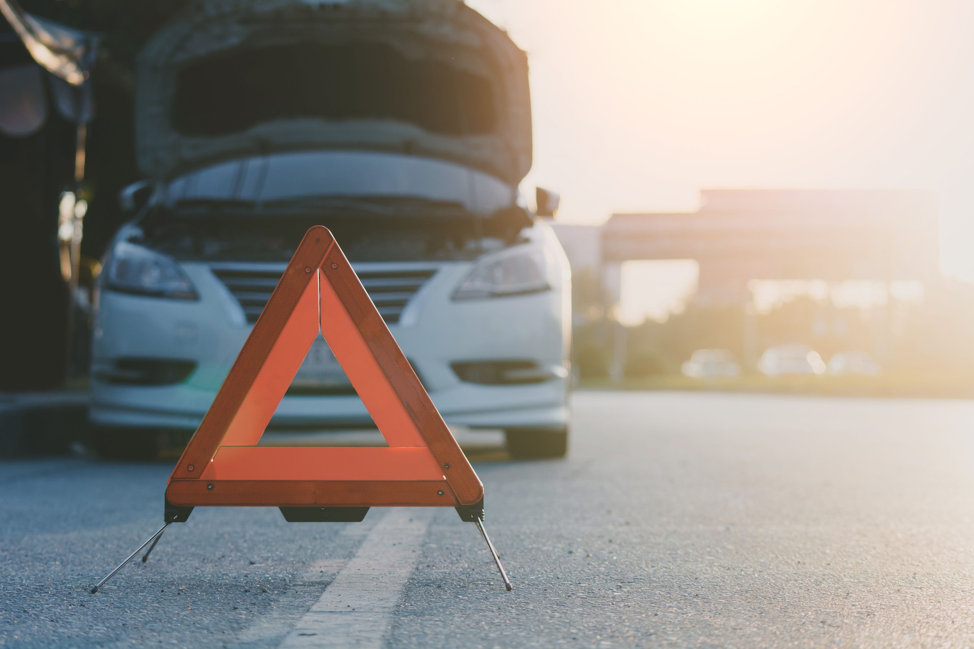 Red emergency sign on a rural road car broken down on highway road safety concept